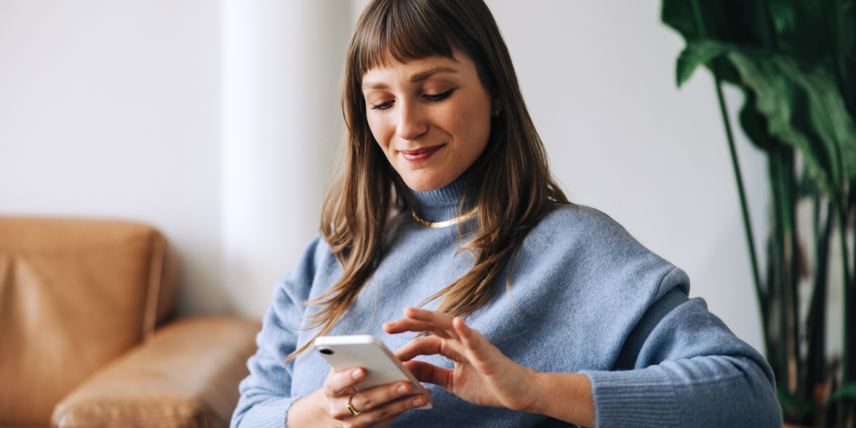 frau schaut glücklich auf ihr handy