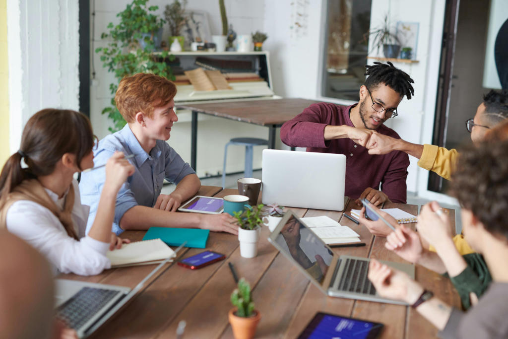 Gruppe junger Menschen arbeitet im grünen Büro