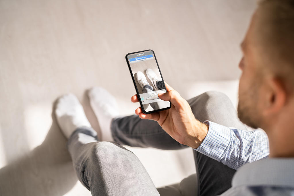 Mann probiert AR Schuhe über das Handy an